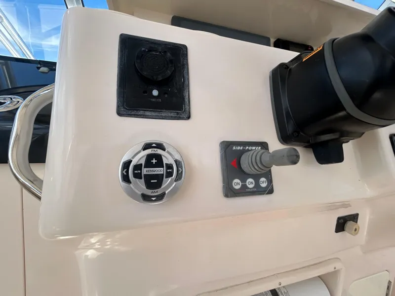 Slide: The Image of Control panel of a 2007 Grady-White Express 305 boat with Kenwood audio controls. - 24