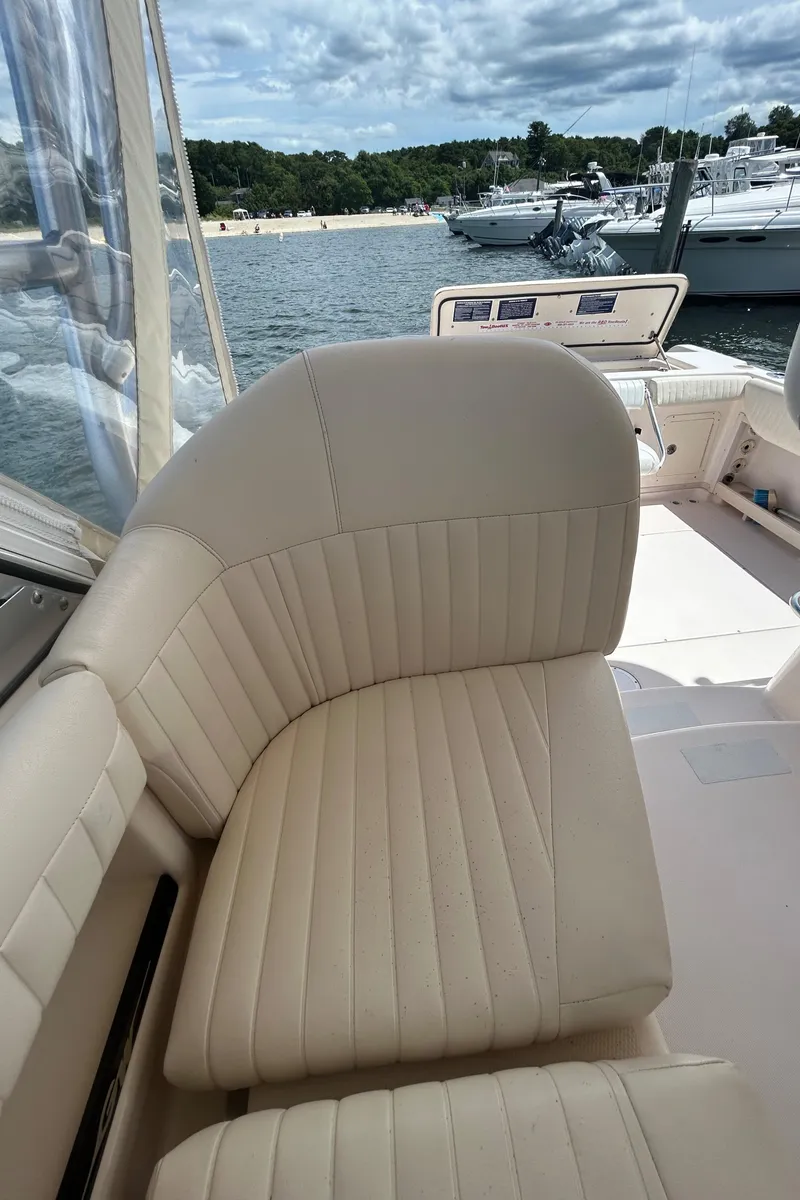 Slide: The Image of 2007 Grady-White Express 305 boat interior with beige seating, docked near other boats. - 29