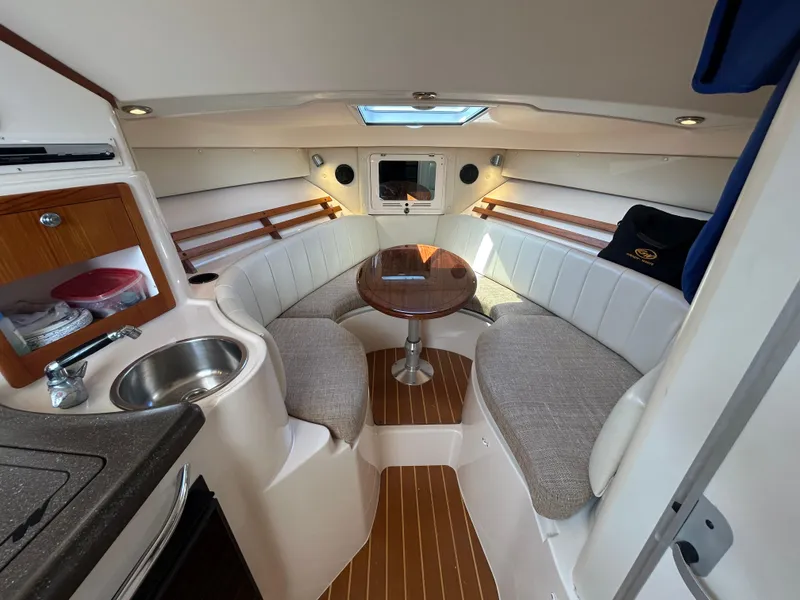 Slide: The Image of 2007 Grady-White Express 305 cabin interior with seating, table, and kitchenette. - 3