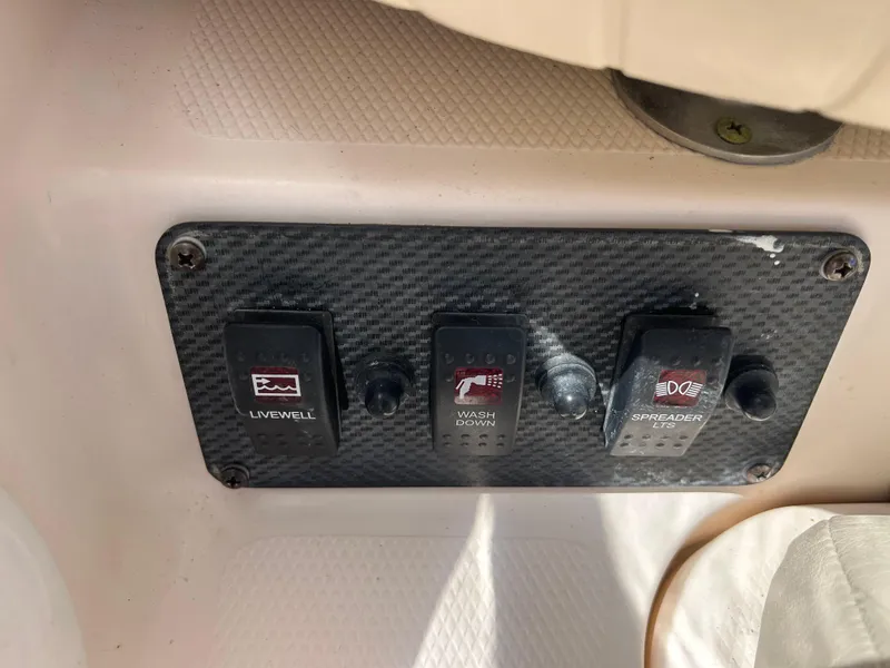 Slide: The Image of Control panel on a 2007 Grady-White Express 305 boat with switches for livewell, washdown, and spreader lights. - 49