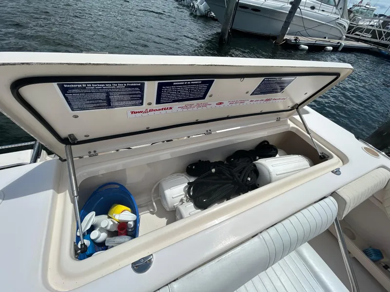 Slide: The Image of Open storage compartment on 2007 Grady-White Express 305 boat, containing ropes and cleaning supplies. - 9