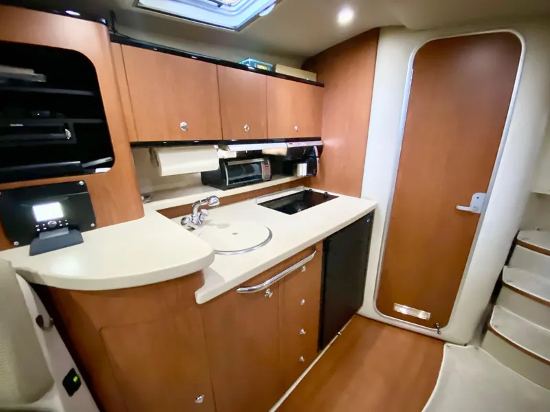 Slide: The Image of 2004 Chaparral Signature 330 yacht interior with modern kitchen and wood cabinetry. - 21