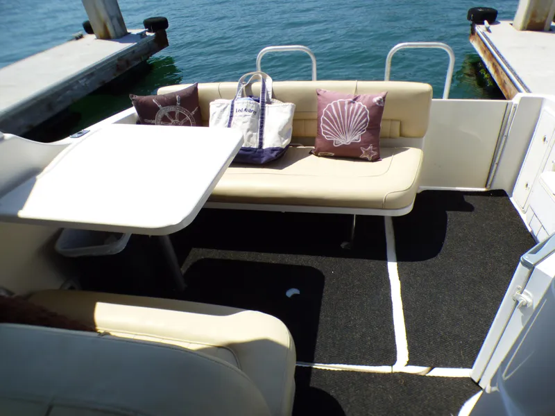 Slide: The Image of 2001 Monterey 302 Cruiser interior with seating, table, and nautical-themed pillows. - 11