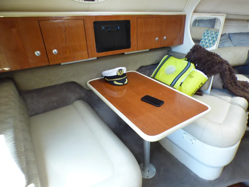 Slide: The Image of Interior of 2001 Monterey 302 Cruiser with table, captain's hat, and seating. - 19