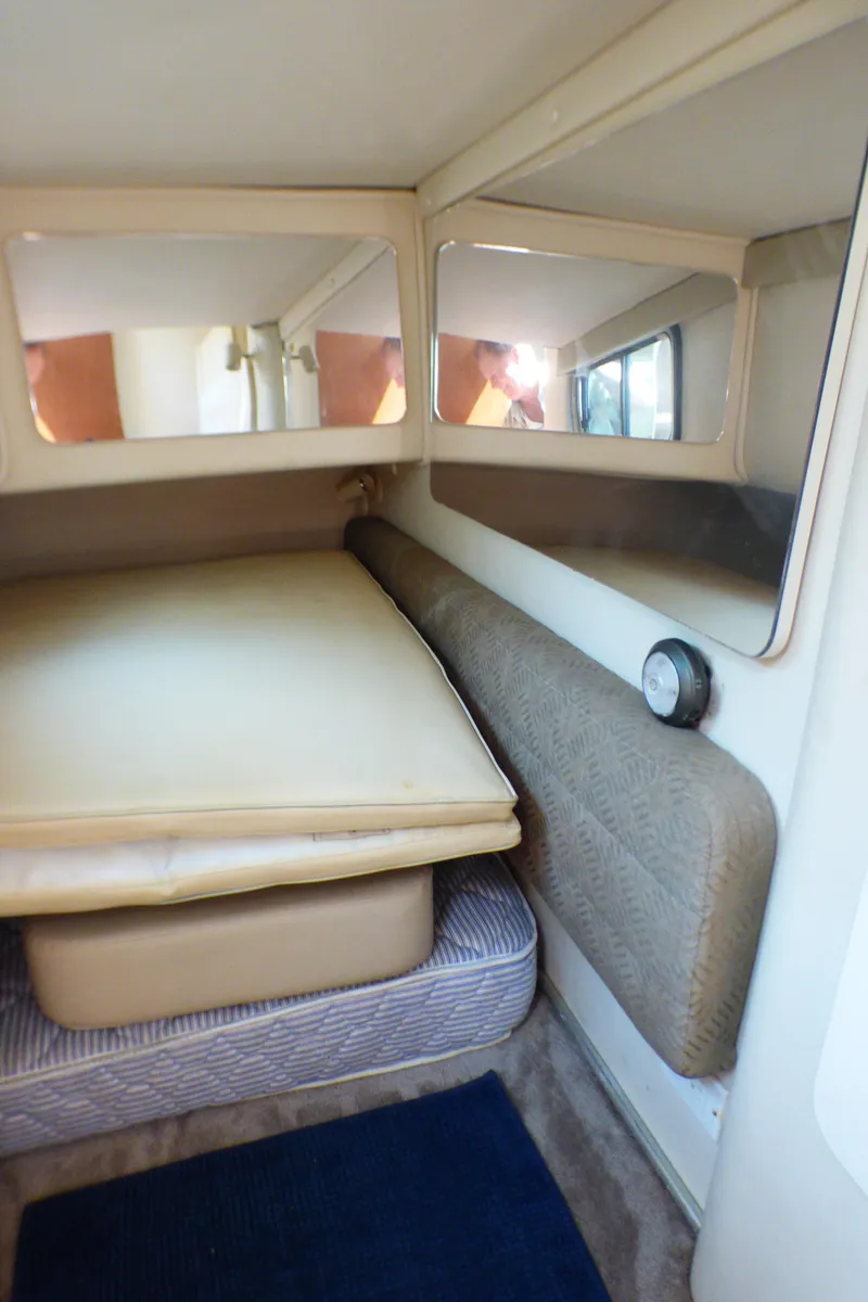 Slide: The Image of 2001 Monterey 302 Cruiser cabin interior with bed, mirrors, and cushioned seating. - 24