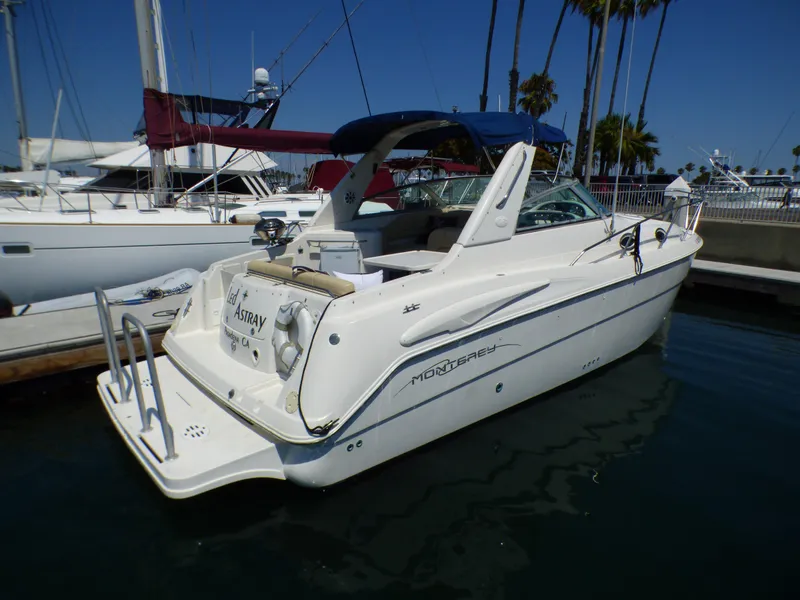 Slide: The Image of 2001 Monterey 302 Cruiser docked at marina, clear sky, palm trees in background. - 5