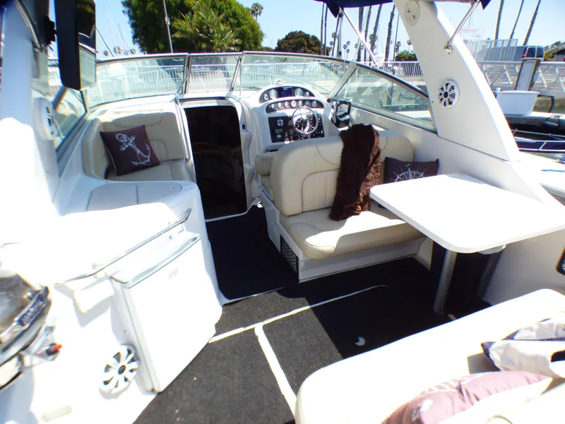 Slide: The Image of 2001 Monterey 302 Cruiser interior with seating, table, and helm, featuring nautical decor. - 8
