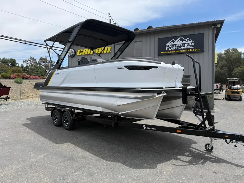 The Image of 2025 Manitou Explore pontoon boat on trailer at California Custom showroom. - 1