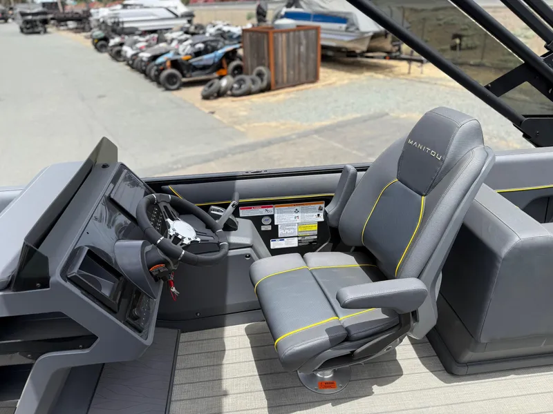 Slide: The Image of 2025 Manitou Explore boat interior with modern steering console and comfortable seating. - 9