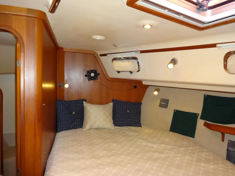 Slide: The Image of Cozy cabin interior of 2006 Island Packet 440 sailboat with wood paneling and comfortable bedding. - 35