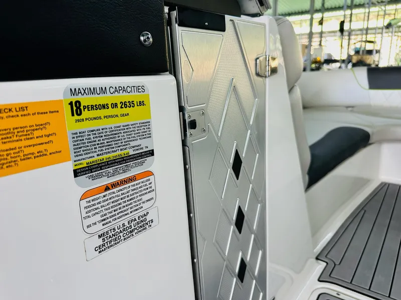 Slide: The Image of 2012 MasterCraft X-45 boat interior showing capacity label and seating area. - 23