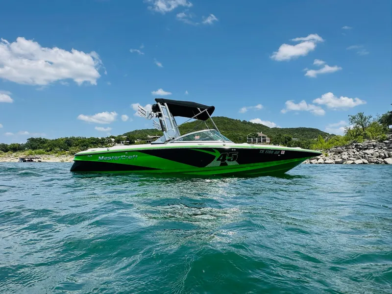 Slide: The Image of 2012 MasterCraft X-45 boat on a sunny lake with clear blue skies. - 4