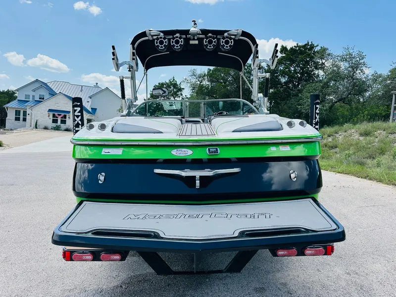 Slide: The Image of 2012 MasterCraft X-45 boat with green and black design, parked outdoors. - 9
