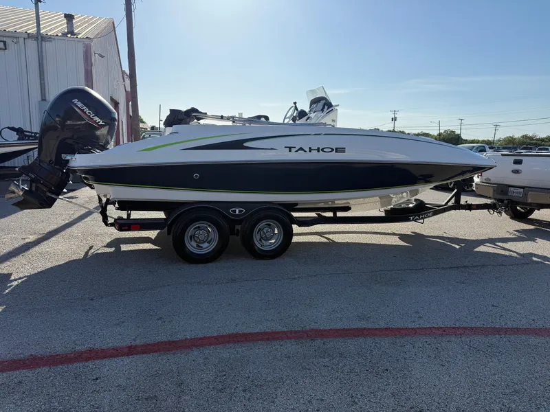 Slide: The Image of 2020 Tahoe 2150 CC boat on trailer, parked outdoors, with Mercury outboard motor. - 14