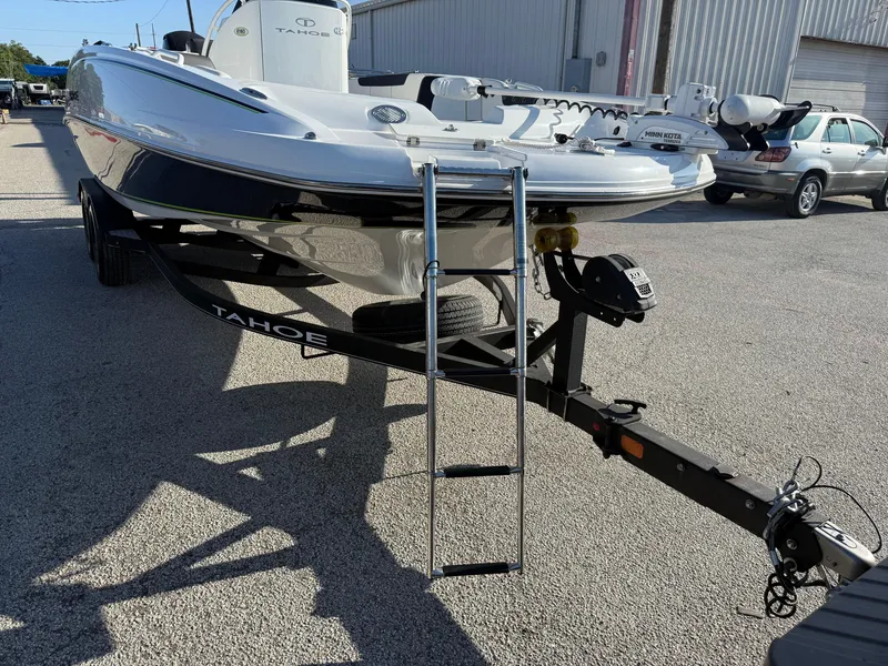 Slide: The Image of 2020 Tahoe 2150 CC boat on trailer, parked outdoors, with visible ladder and equipment. - 16