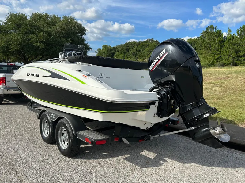 Slide: The Image of 2020 Tahoe 2150 CC boat on trailer with Mercury outboard motor, parked outdoors. - 2