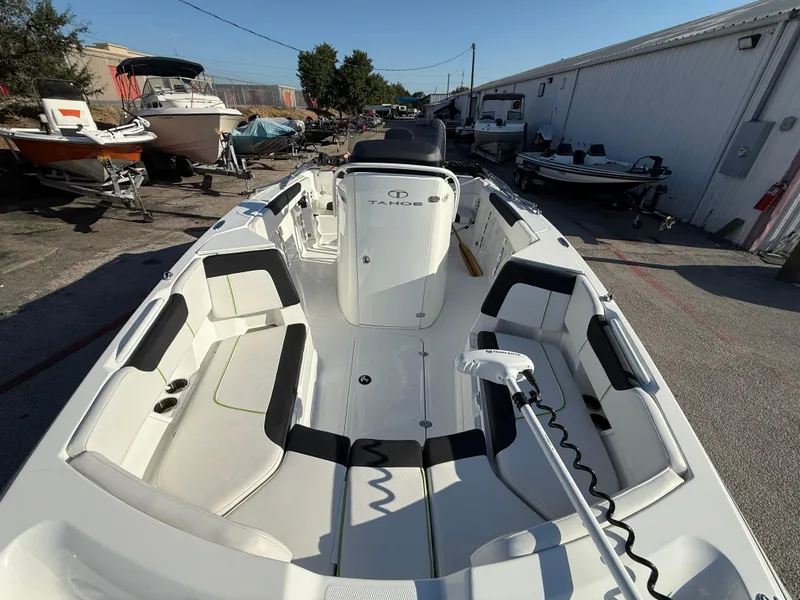 Slide: The Image of 2020 Tahoe 2150 CC boat interior with seating and equipment, parked outdoors. - 20