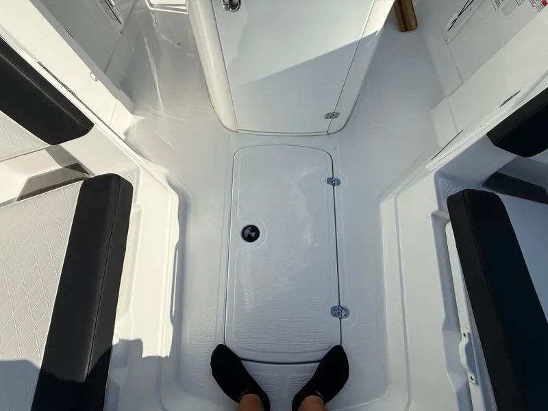 Slide: The Image of 2020 Tahoe 2150 CC boat interior with black seating and white flooring. - 25