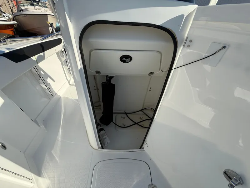 Slide: The Image of 2020 Tahoe 2150 CC boat storage compartment with open door, showcasing interior space. - 28