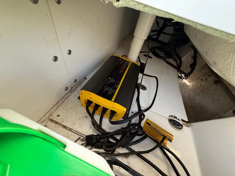 Slide: The Image of 2020 Tahoe 2150 CC boat interior with battery charger and wiring setup. - 44