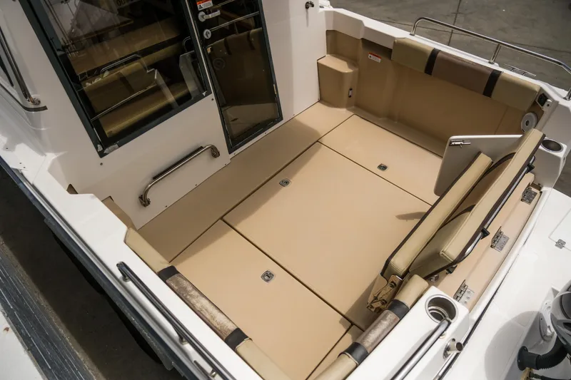 Slide: The Image of 2018 Ranger Tugs R-23 boat interior with beige seating and storage compartments. - 10