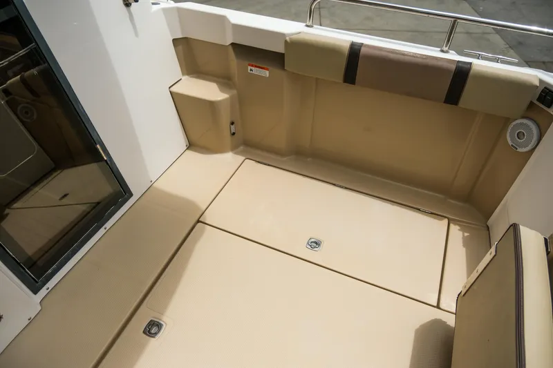 Slide: The Image of 2018 Ranger Tugs R-23 boat interior with beige flooring and seating area. - 12
