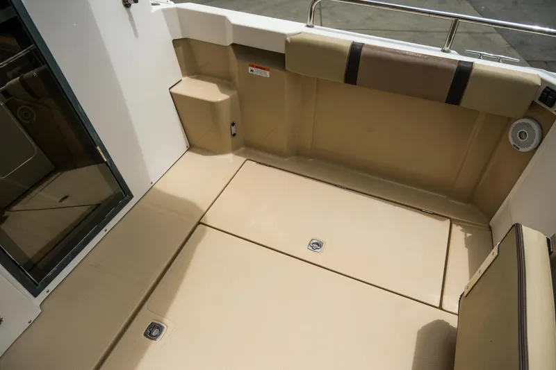 Slide: The Image of 2018 Ranger Tugs R-23 boat interior with beige seating and storage compartments. - 13