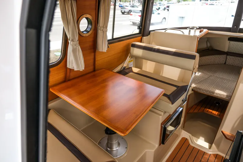 Slide: The Image of 2018 Ranger Tugs R-23 interior with wooden table and seating area. - 20