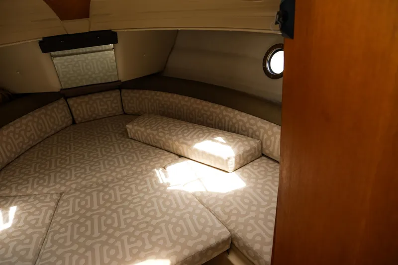 Slide: The Image of 2018 Ranger Tugs R-23 cabin interior with patterned cushions and porthole window. - 25
