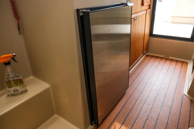Slide: The Image of Interior of 2018 Ranger Tugs R-23 with fridge and wooden flooring. - 29