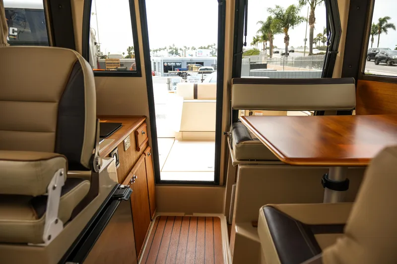 Slide: The Image of Interior of 2018 Ranger Tugs R-23 boat with seating and wooden table. - 30