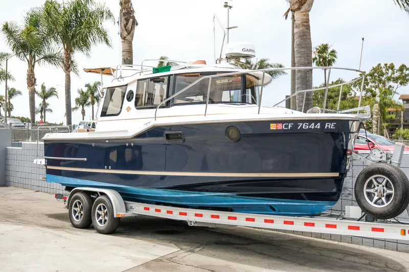 Slide: The Image of 2018 Ranger Tugs R-23 boat on trailer, parked with palm trees in the background. - 35