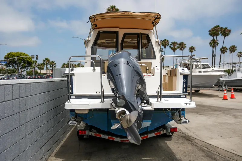 Slide: The Image of 2018 Ranger Tugs R-23 boat with outboard motor on trailer, parked outdoors. - 4