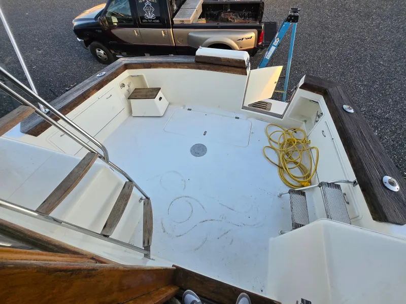 Slide: The Image of 1988 Ocean 35 Super Sport boat deck with wooden trim and coiled yellow hose. - 17
