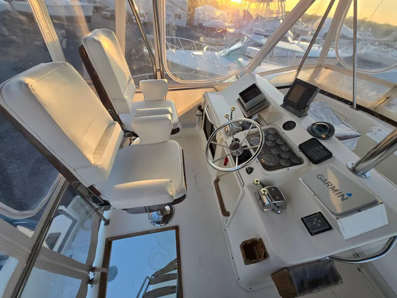 Slide: The Image of 1988 Ocean 35 Super Sport helm with dual seats and Garmin navigation system at sunset. - 2