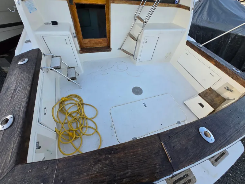 Slide: The Image of 1988 Ocean 35 Super Sport boat deck with wooden trim and yellow rope. - 35