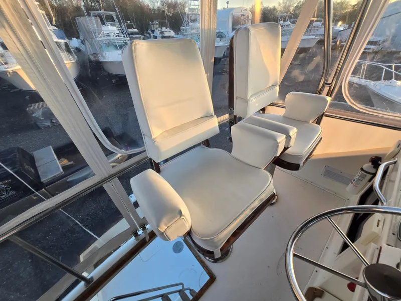 Slide: The Image of Interior of 1988 Ocean 35 Super Sport boat with white captain chairs and steering wheel. - 4