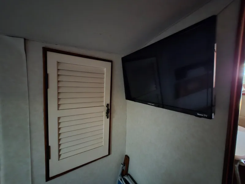 Slide: The Image of Interior of 1988 Ocean 35 Super Sport with wall-mounted TV and louvered cabinet. - 41