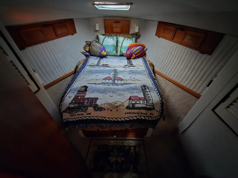 Slide: The Image of Cozy cabin bedroom in 1988 Ocean 35 Super Sport boat with lighthouse-themed bedding. - 5