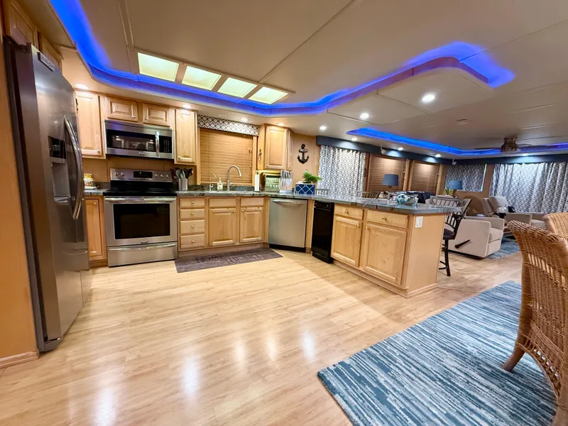 Slide: The Image of Luxurious 2001 Sumerset 18x104 houseboat kitchen with modern appliances and ambient blue lighting. - 11