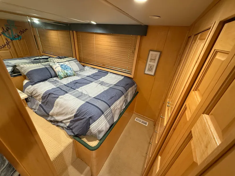 Slide: The Image of Cozy bedroom in 2001 Sumerset 18x104 houseboat with striped bedding and wood paneling. - 13