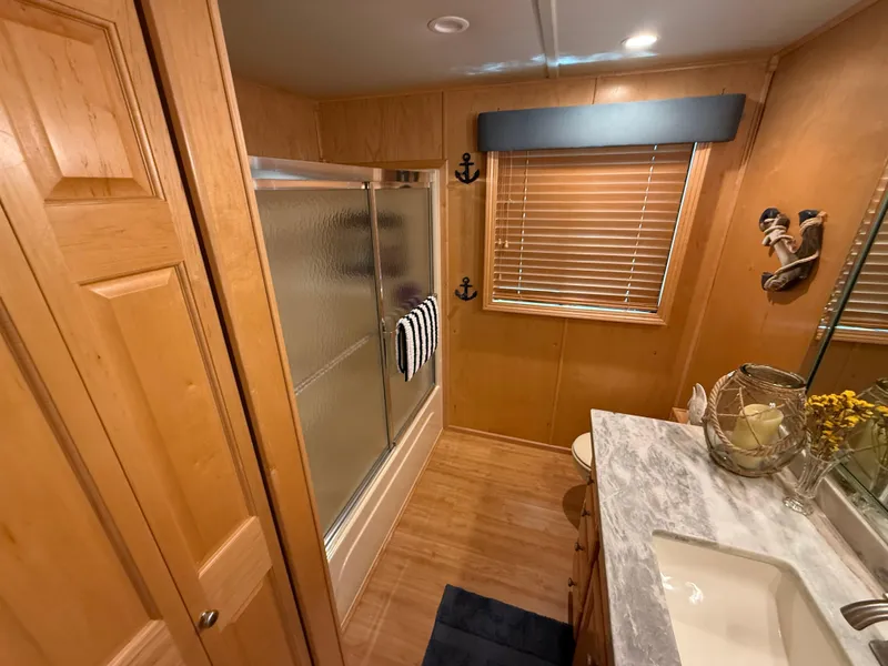 Slide: The Image of Bathroom interior of 2001 Sumerset 18x104 houseboat with wood paneling and nautical decor. - 17