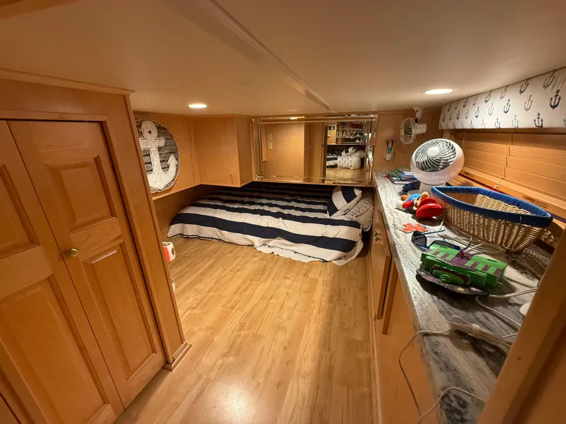 Slide: The Image of Cozy bedroom in 2001 Sumerset 18x104 houseboat with nautical decor and wooden furnishings. - 20