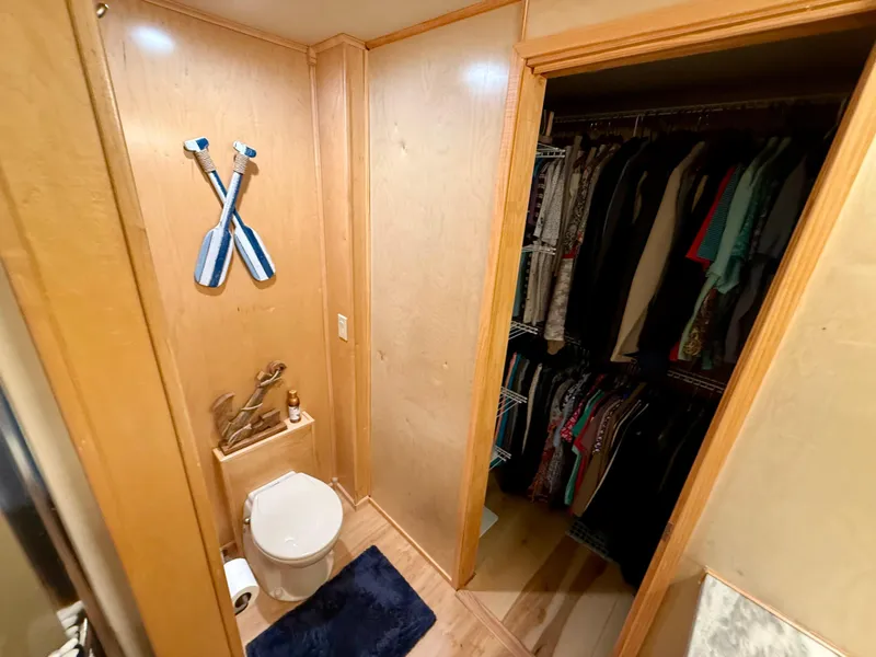 Slide: The Image of Compact bathroom with wooden walls, toilet, nautical decor, and adjacent closet in 2001 Sumerset houseboat. - 30