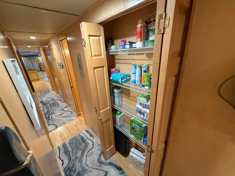 Slide: The Image of Hallway with open pantry in 2001 Sumerset 18x104 houseboat, showcasing organized shelves. - 41