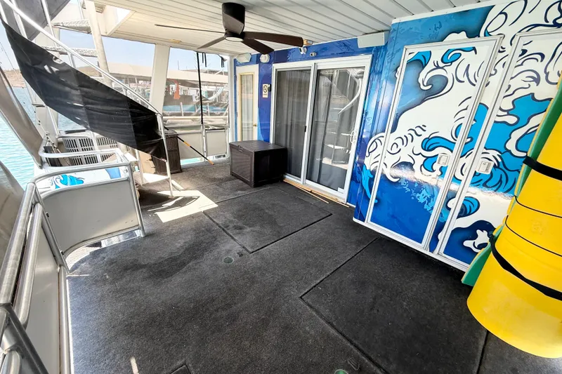 Slide: The Image of Houseboat deck with ocean-themed mural, ceiling fan, and sliding glass doors. Sumerset 18x104, 2001 model. - 77