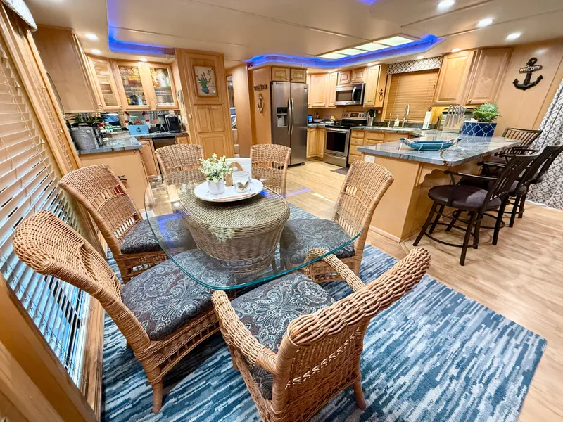 Slide: The Image of Luxurious 2001 Sumerset 18x104 houseboat interior with wicker dining set and modern kitchen. - 8