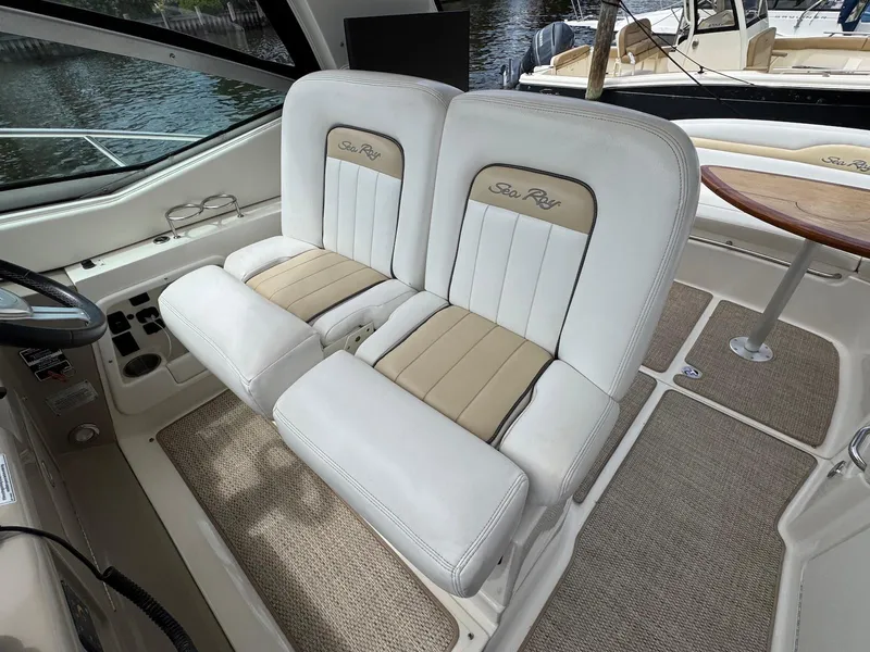 Slide: The Image of 2008 Sea Ray 350 Sundancer cockpit with dual white and beige seats. - 11