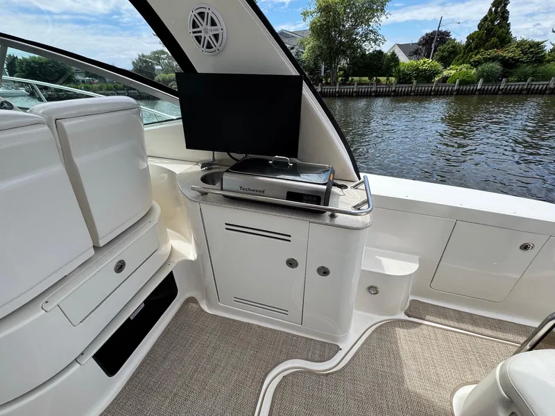 Slide: The Image of 2008 Sea Ray 350 Sundancer interior with TV and grill by the water. - 13