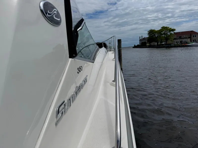 Slide: The Image of 2008 Sea Ray 350 Sundancer yacht docked by waterfront homes under cloudy sky. - 19
